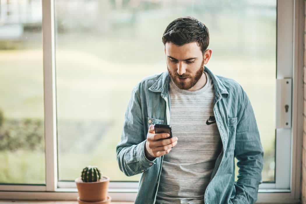 man holding and using phone 