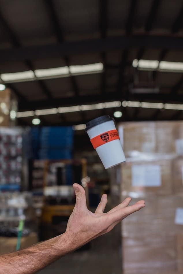 the man's hand toss the paper cup