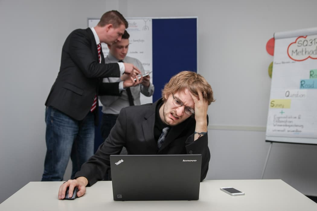 man working with laptop has a headache because of work
